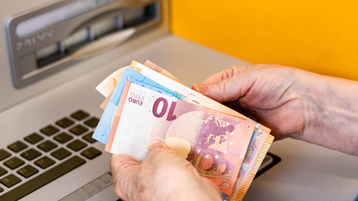 Close-up, woman's hands counting euro bills at the ATM